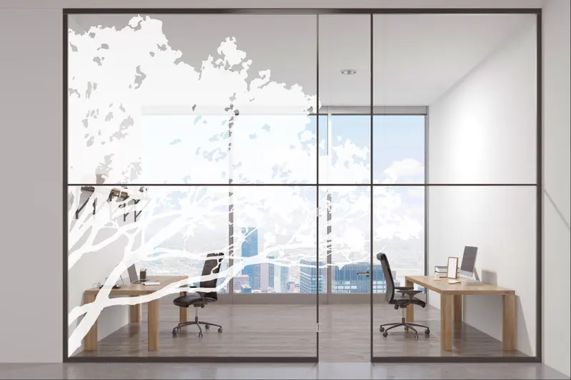 Simulation : bureau vitré dont les baies sont couvertes de branches d’arbre en silhouette blanche
